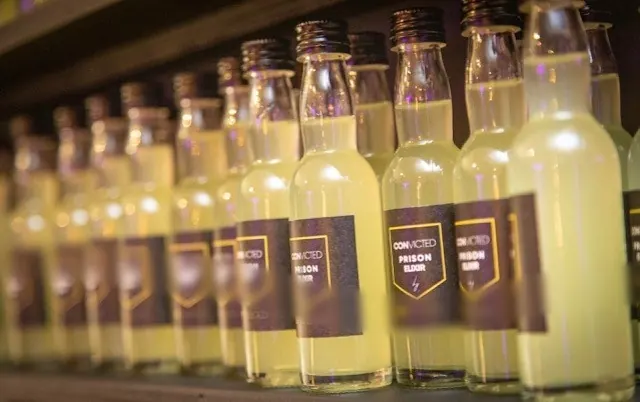 Rij limoncello-flesjes met eigen etiketten in de huisstijl van een event