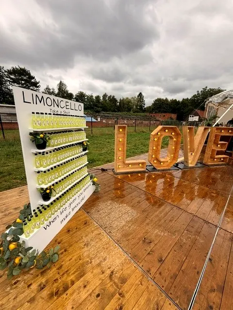 Limoncello Wall met LOVE-letters op een festivalbruiloft