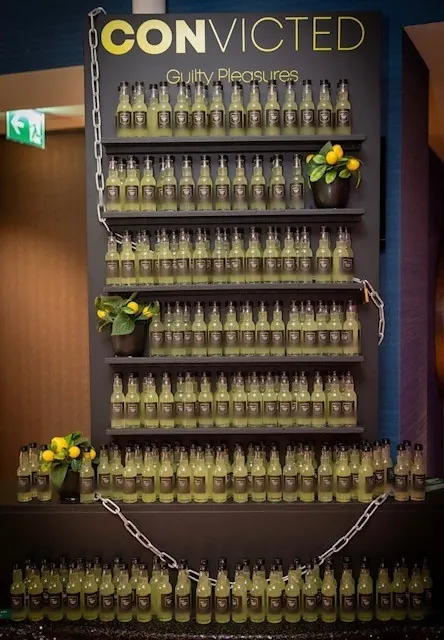 Zwarte Limoncello Wall in thema met eigen etiketten en kettingen op een zakelijk event