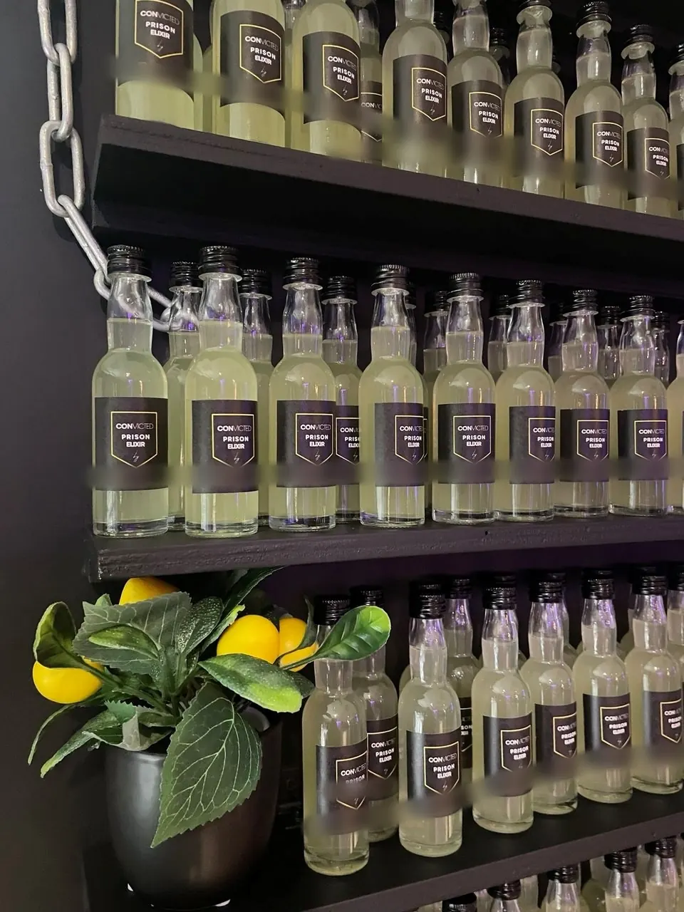 Close-up van flesjes met eigen etiketten op een thema-wall