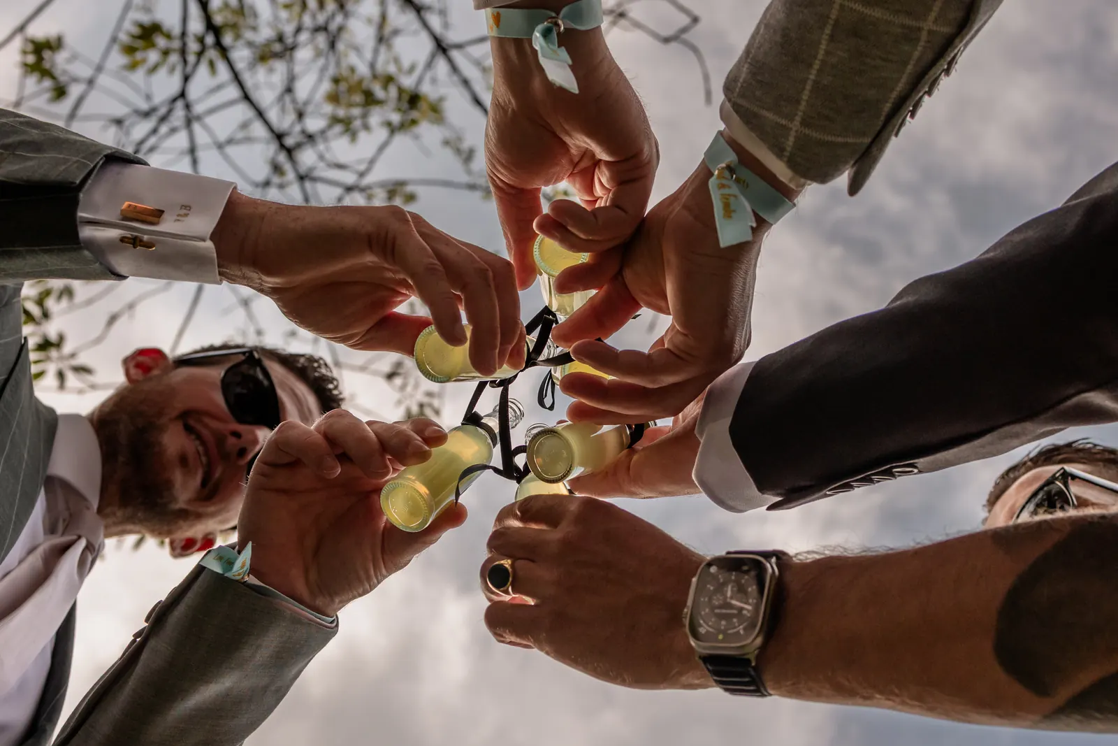 Vrienden proosten met mini-flesjes limoncello op de bruiloft van Femke en Barend